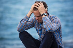 A man putting hands on his head because he’s dealing with the invisible struggles of high-functioning anxiety.