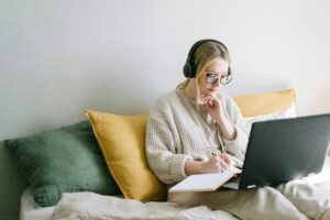 woman with headphones doing teletherapy definition