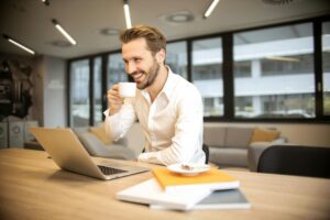 Man at desk with coffee with imposter syndrome at work