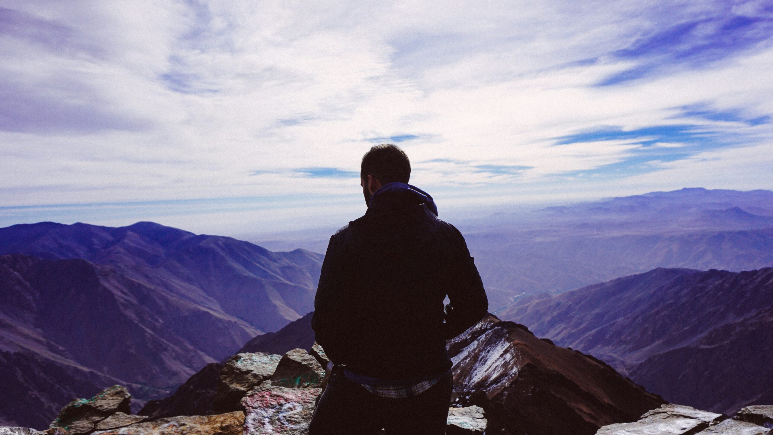 man on mountain after receiving therapy for high achievers