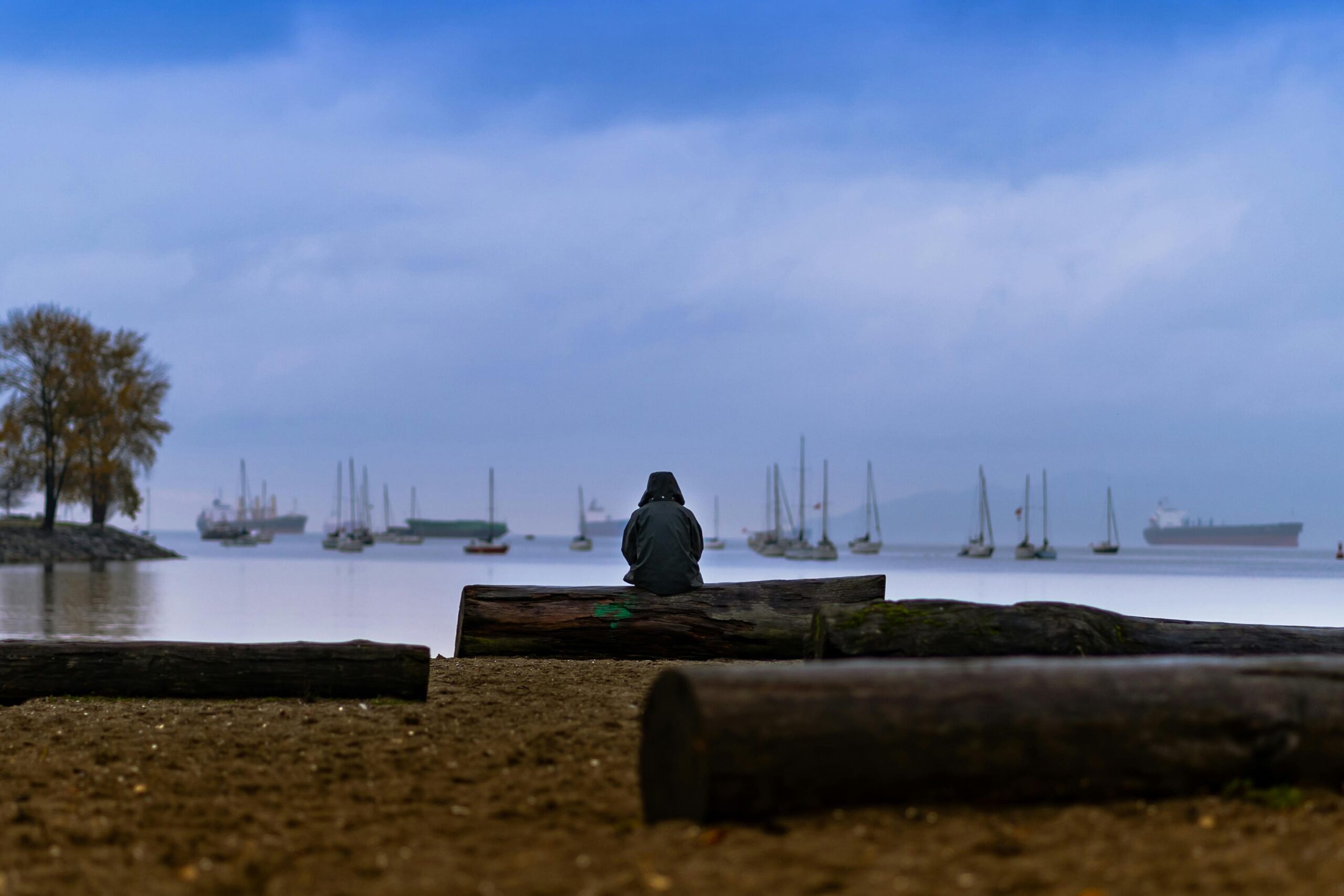 person sitting on a log wondering "Will I ever be good enough?"