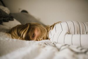 A person lying in their bed wondering about how to calm her anxiety at night