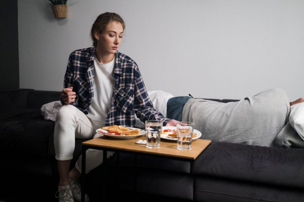 A woman serving food while her partner lies down